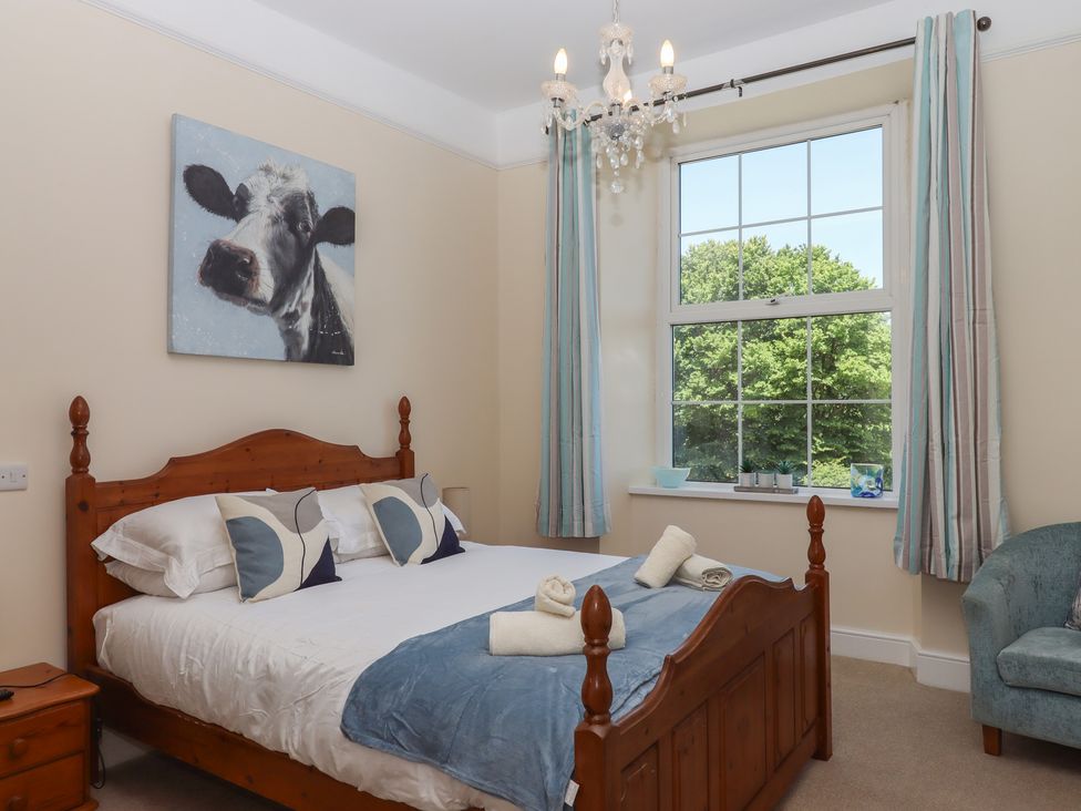 A bedroom with a bed and a painting at Littleham Court Manor in Littleham near Bideford