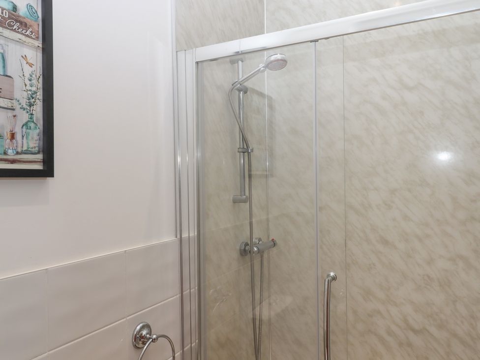 A shower with glass door and wall art in a bathroom at Littleham Court Manor Littleham near Bideford