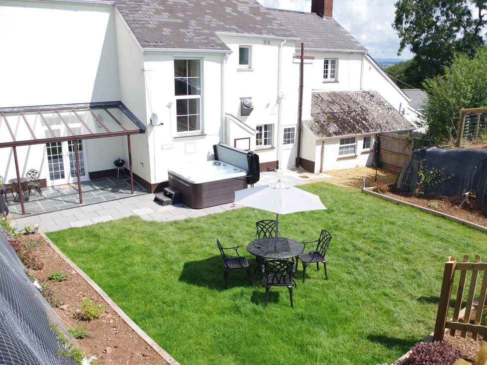 A garden with a hot tub and seating area at Littleham Court Manor Littleham near Bideford
