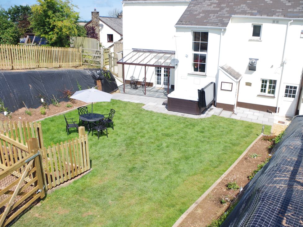 A garden with grass, a table and chairs and a parasol at Littleham Court Manor in Littleham near Bideford