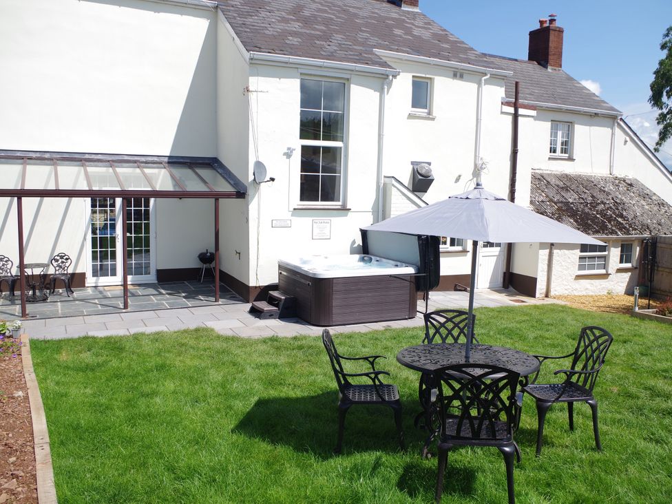 A garden with a hot tub and outdoor seating at Littleham Court Manor in Littleham near Bideford