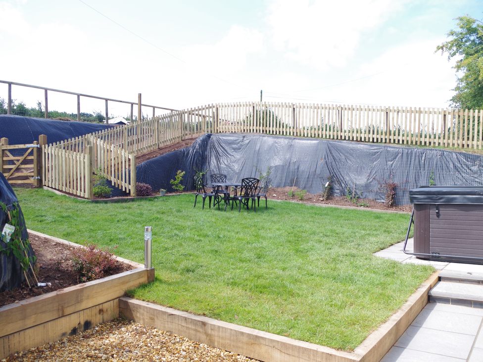 A garden with a hot tub and outdoor furniture at Littleham Court Manor in Littleham near Bideford