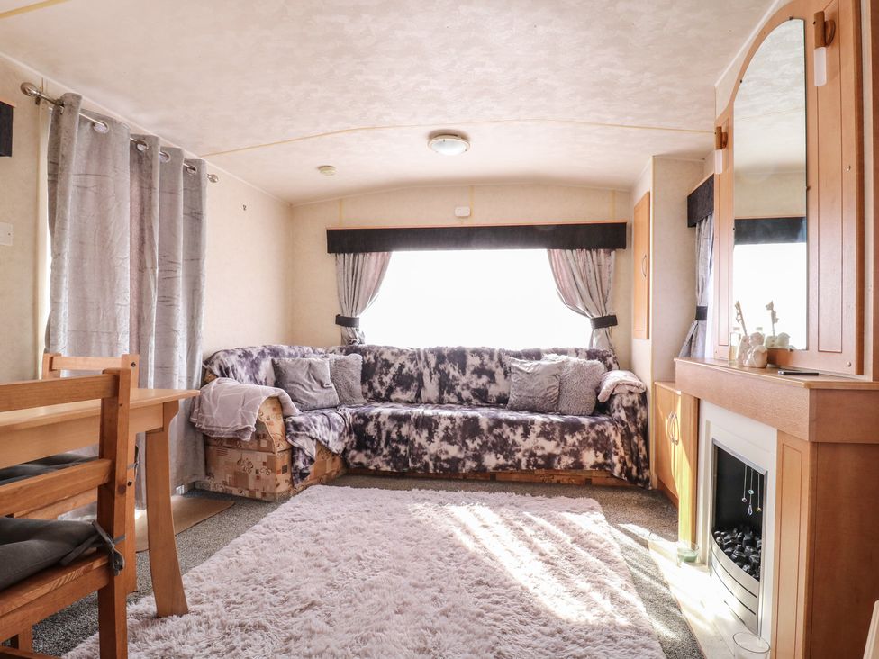 A living room with a sofa and dining table at Caravan Northampton
