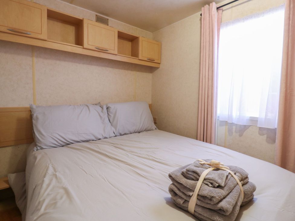 A bedroom with a bed and shelves at the Caravan in Northampton
