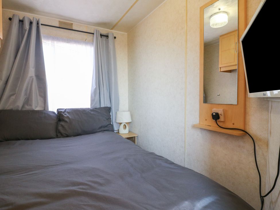 A bedroom with a bed and a TV at Caravan in Northampton