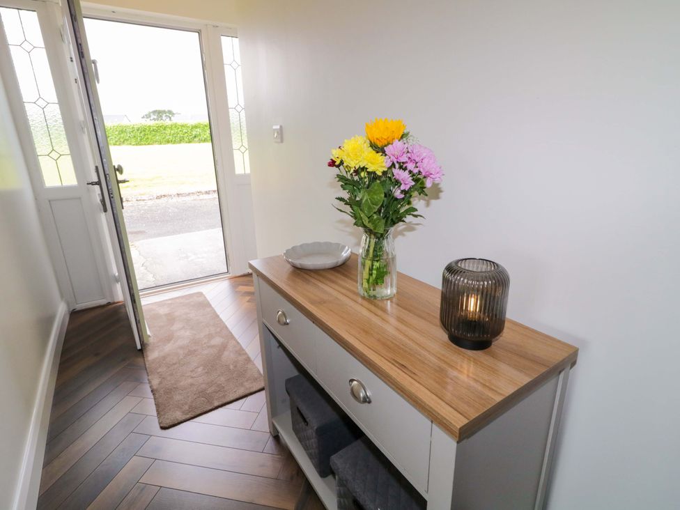 An entrance hall with a table and flowers at Ard Na Mara 