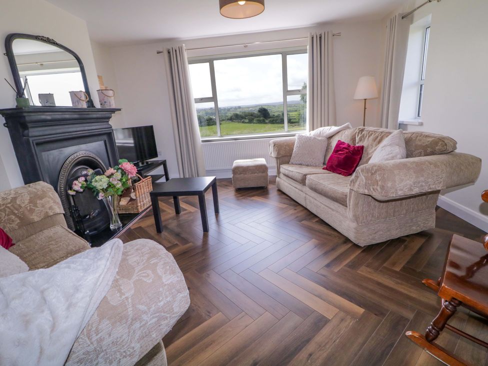 A living room with a sofa and a television at Ard Na Mara in 
