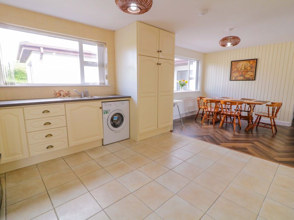 A kitchen with a dining area and a washing machine at Ard Na Mara