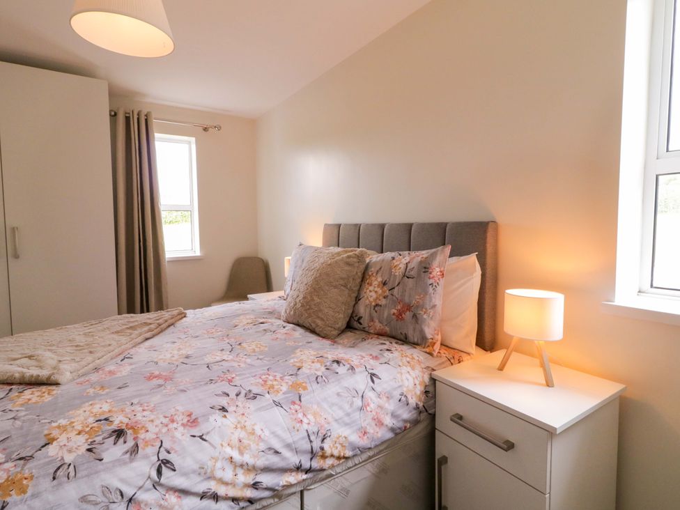 A bedroom with a bed and a bedside lamp at Ard Na Mara 