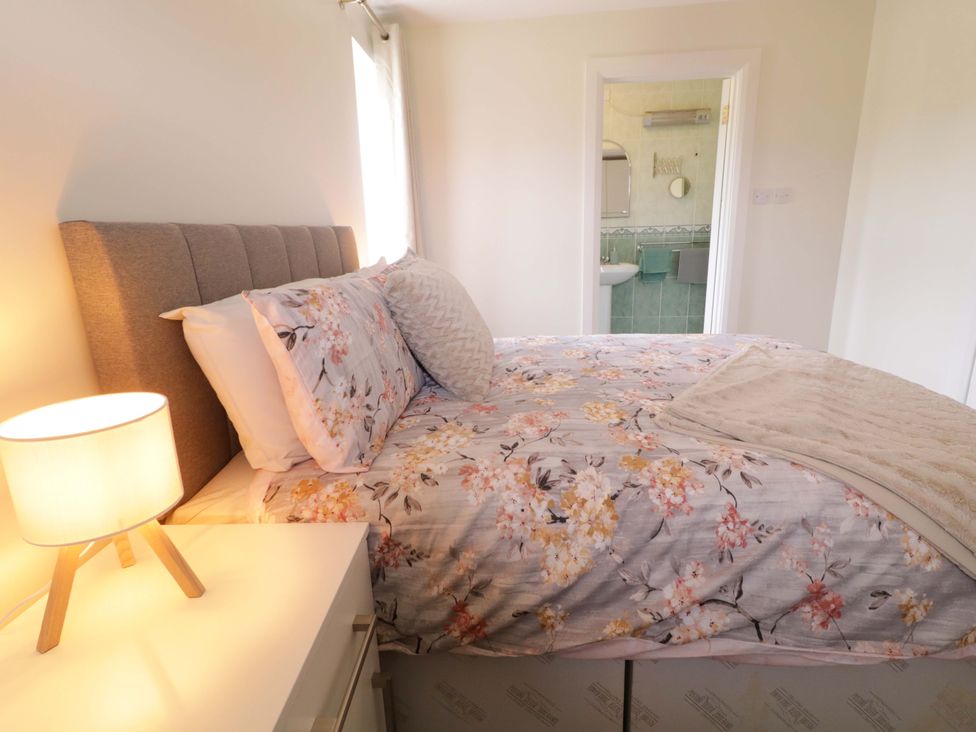 A bedroom with a bed and a lamp at Ard Na Mara 