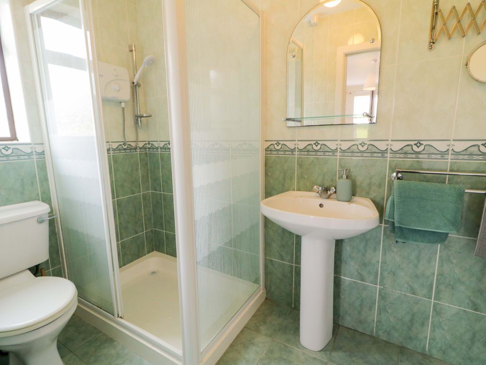 A bathroom with a shower, toilet, and sink at Ard Na Mara