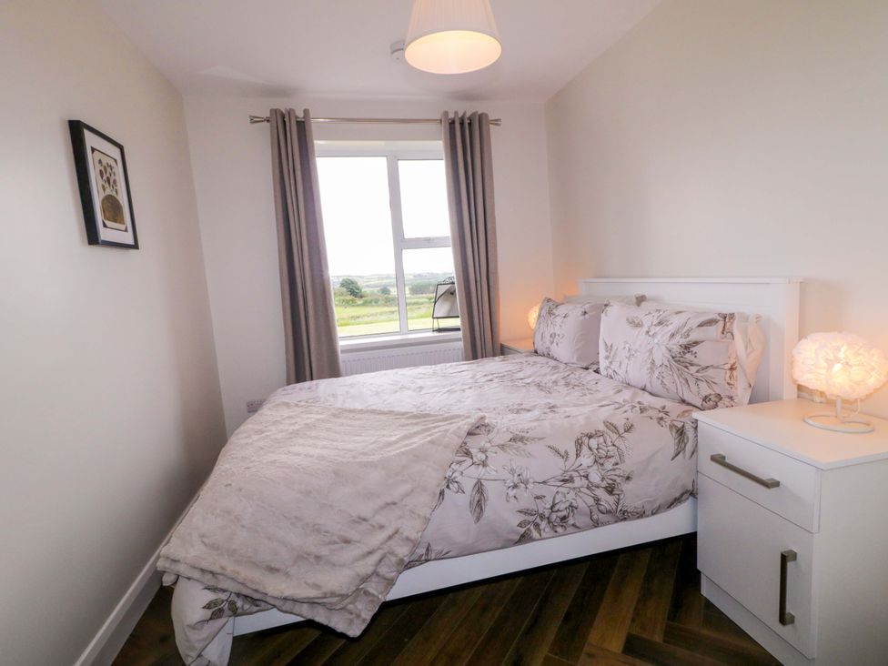 A bedroom with a bed and a bedside table at Ard Na Mara