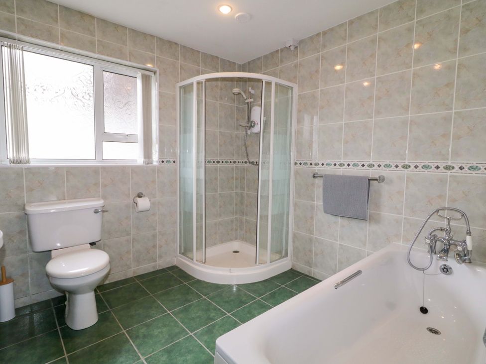 A bathroom with shower, bathtub, toilet, and towel at Ard Na Mara