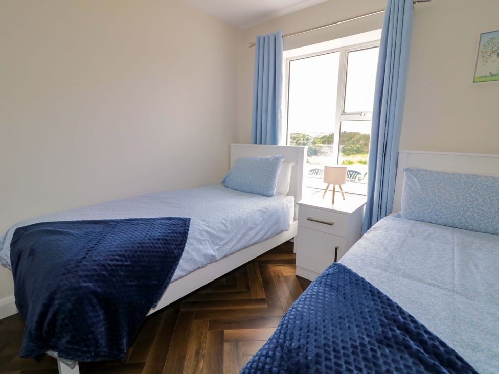 A bedroom with two twin beds and a window at Ard Na Mara