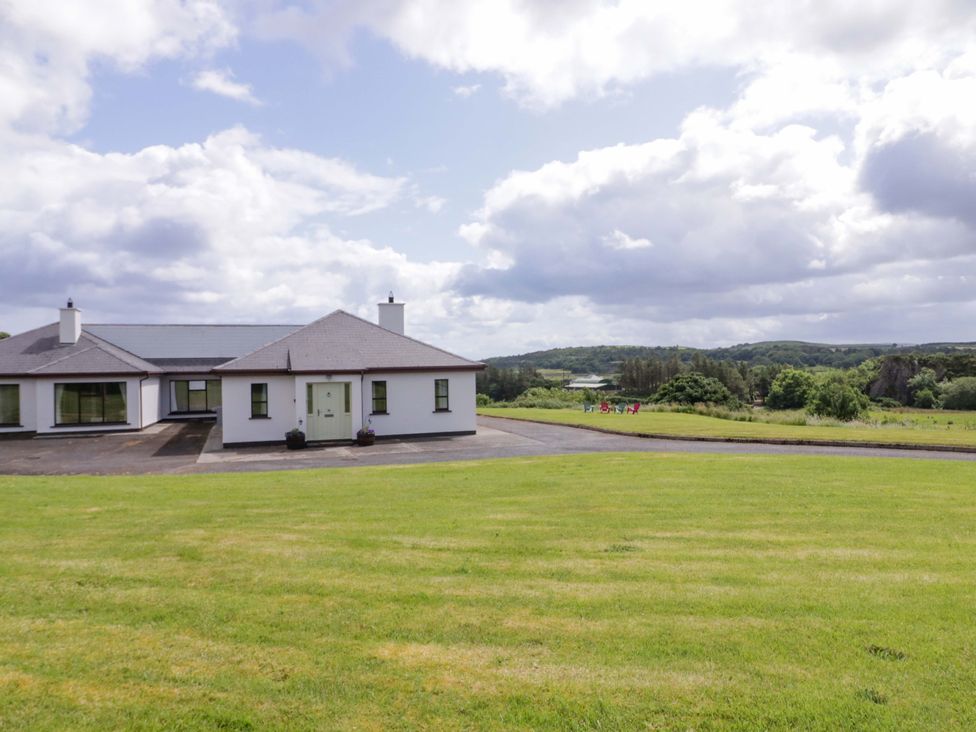 A house with a lawn and trees at Ard Na Mara