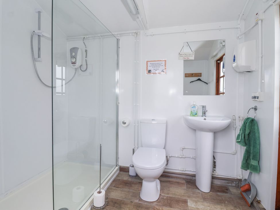 A bathroom with a shower, toilet, and sink at Shepherd's Hut Market Weighton