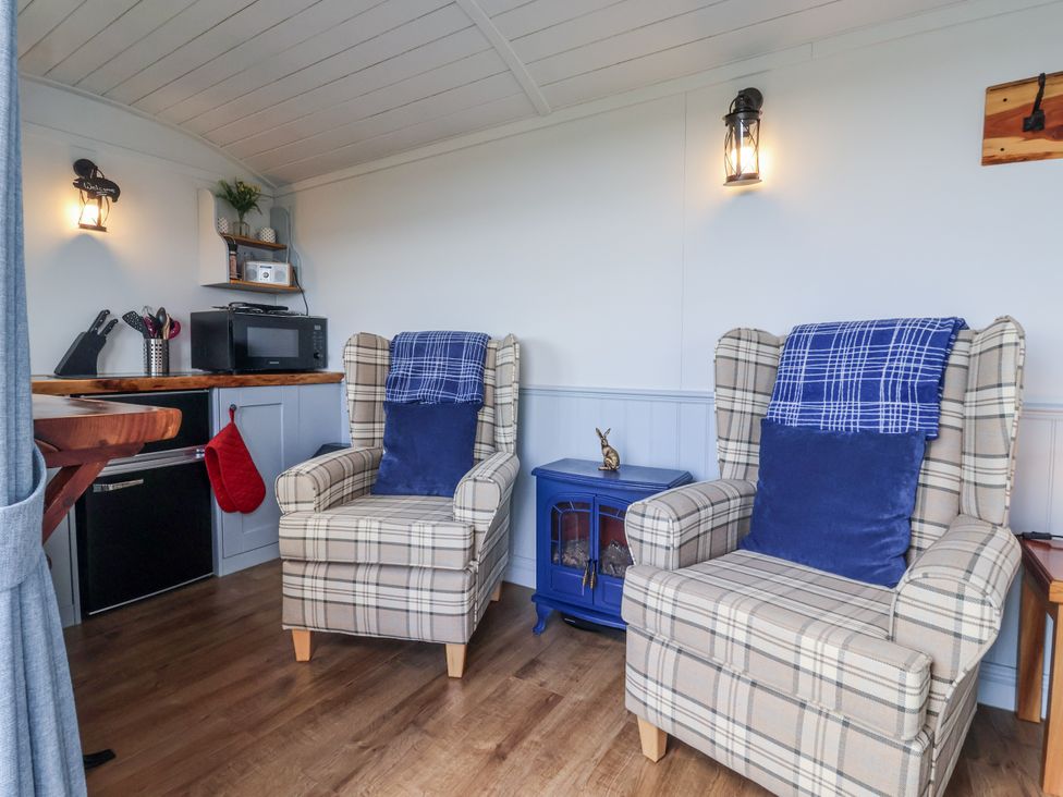A snug with two chairs and a table at Wolds Hoot in Market Weighton