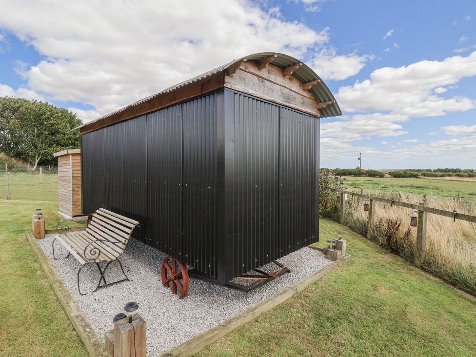 A shed and bench in a garden at Wolds Hoot Market Weighton