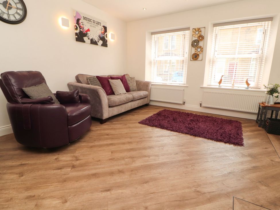 A living room with an armchair and sofa at Flat 1 in Carnforth