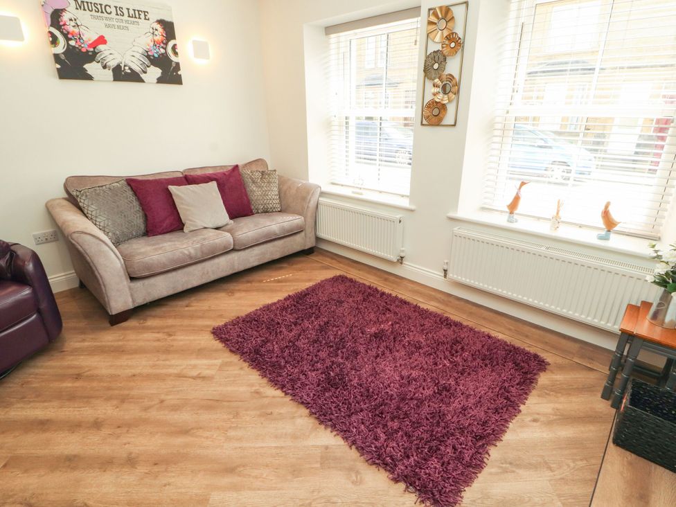 A living room with a sofa and rug at Flat 1 in Carnforth