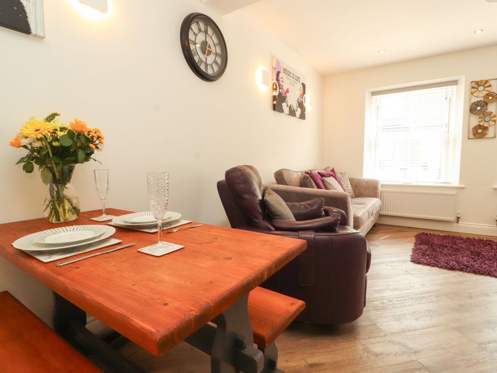 A living room with a table set for dining at Flat 1 in Carnforth