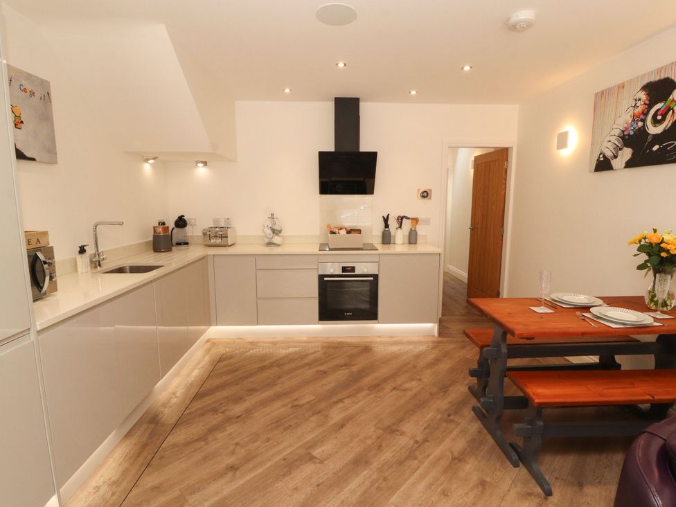 A kitchen with cabinets and a dining table at Flat 1 in Carnforth