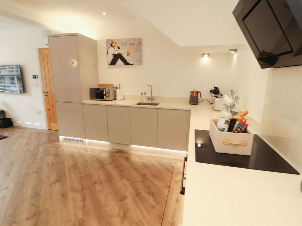 A kitchen with cabinets and appliances at Flat 1 Carnforth