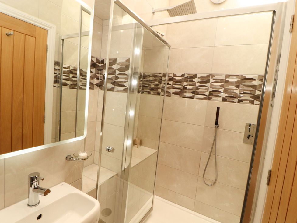 A bathroom with a shower and sink at Flat 1 in Carnforth