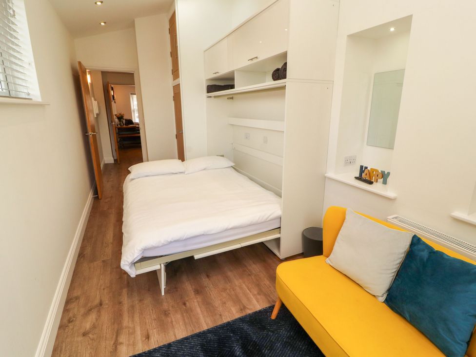 A bedroom with a bed and a sofa at Flat 1 in Carnforth