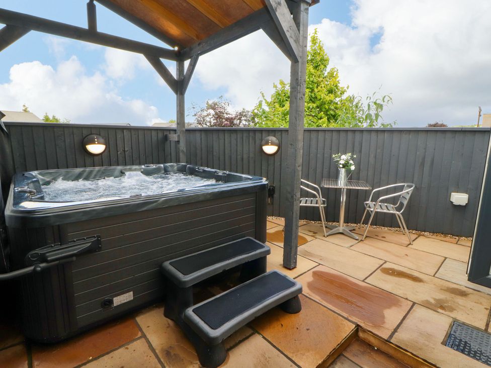 An outdoor area with a hot tub and seating at Flat 1 in Carnforth