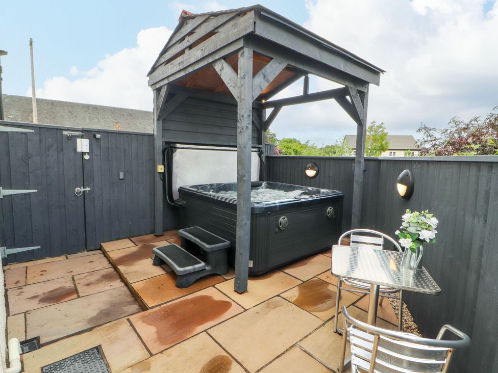 An outdoor area with a hot tub and seating at Flat 1 in Carnforth