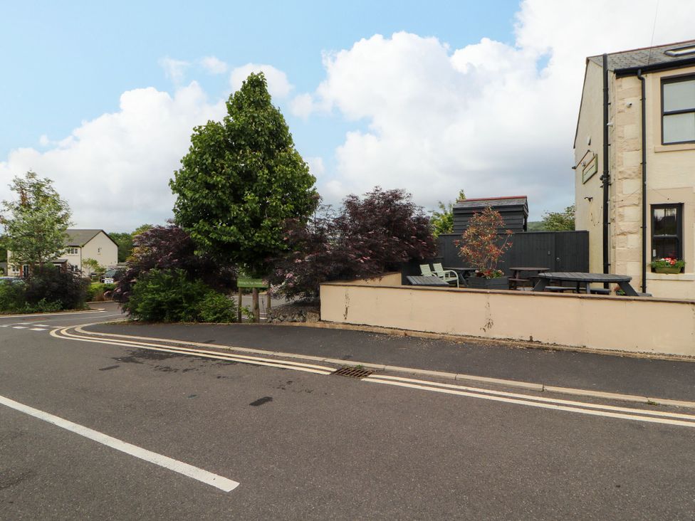 An outdoor scene with trees and a bench at Flat 1 in Carnforth