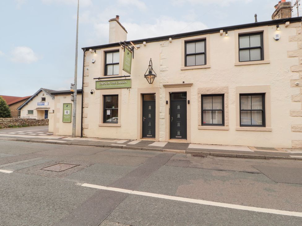 A building with a sign and doors at Flat 2 Carnforth