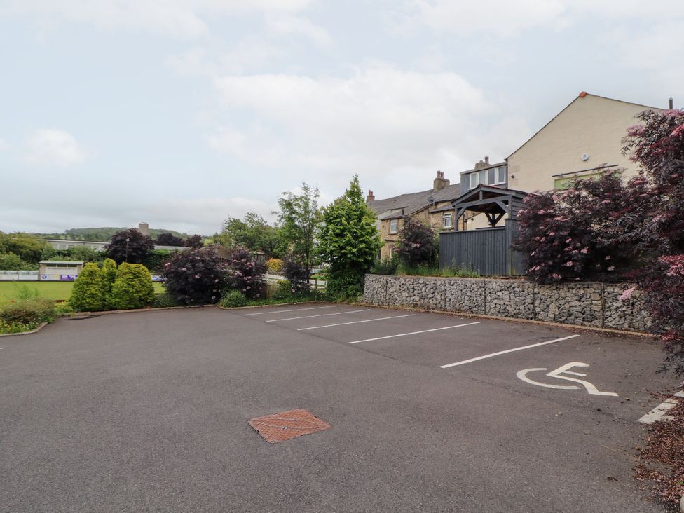 A parking lot with trees and bushes at Flat 2 in Carnforth