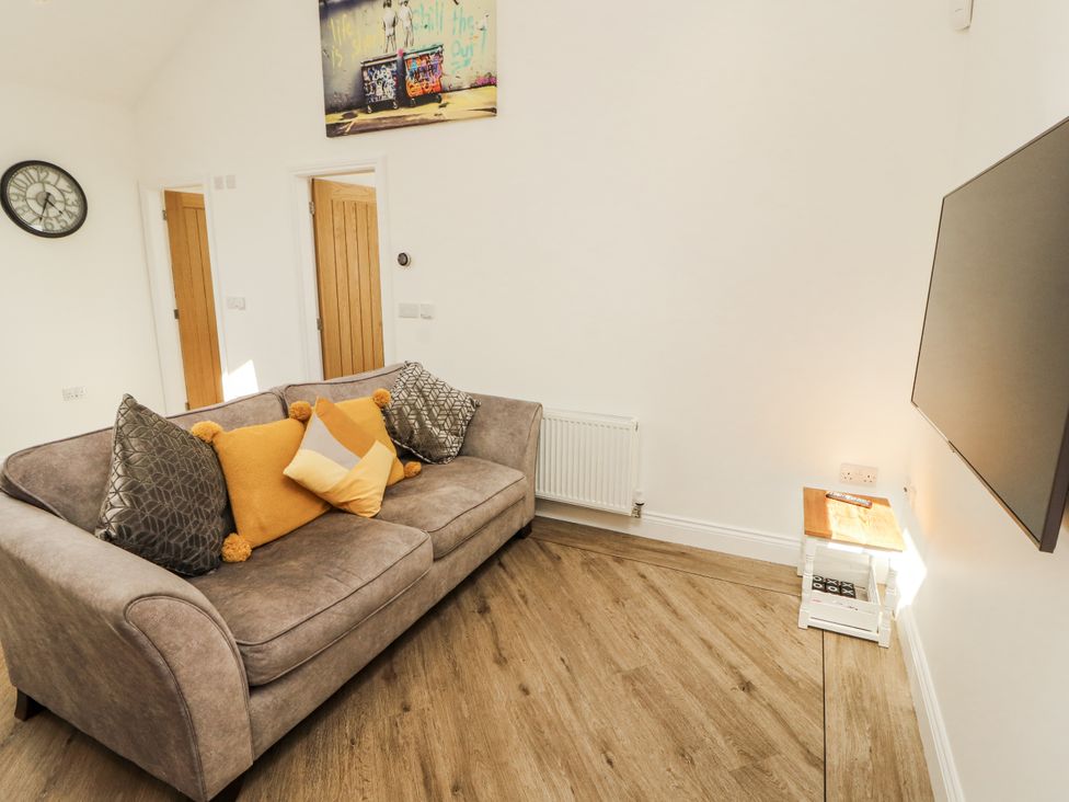 A living room with a sofa and television at Flat 2 in Carnforth