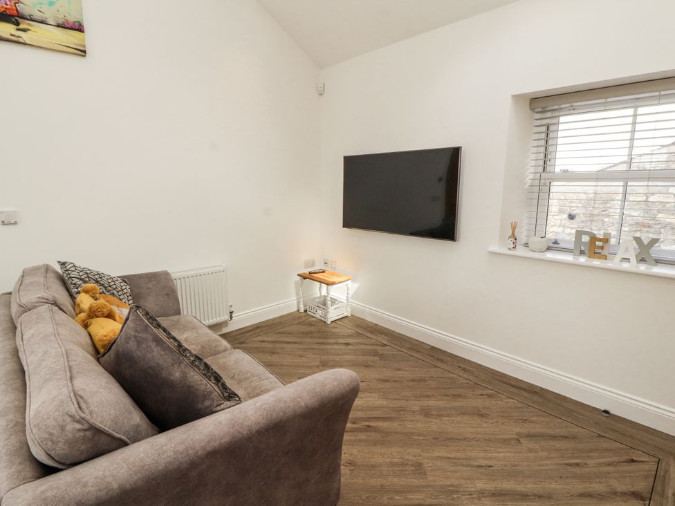A living room with a sofa and television at Flat 2 in Carnforth