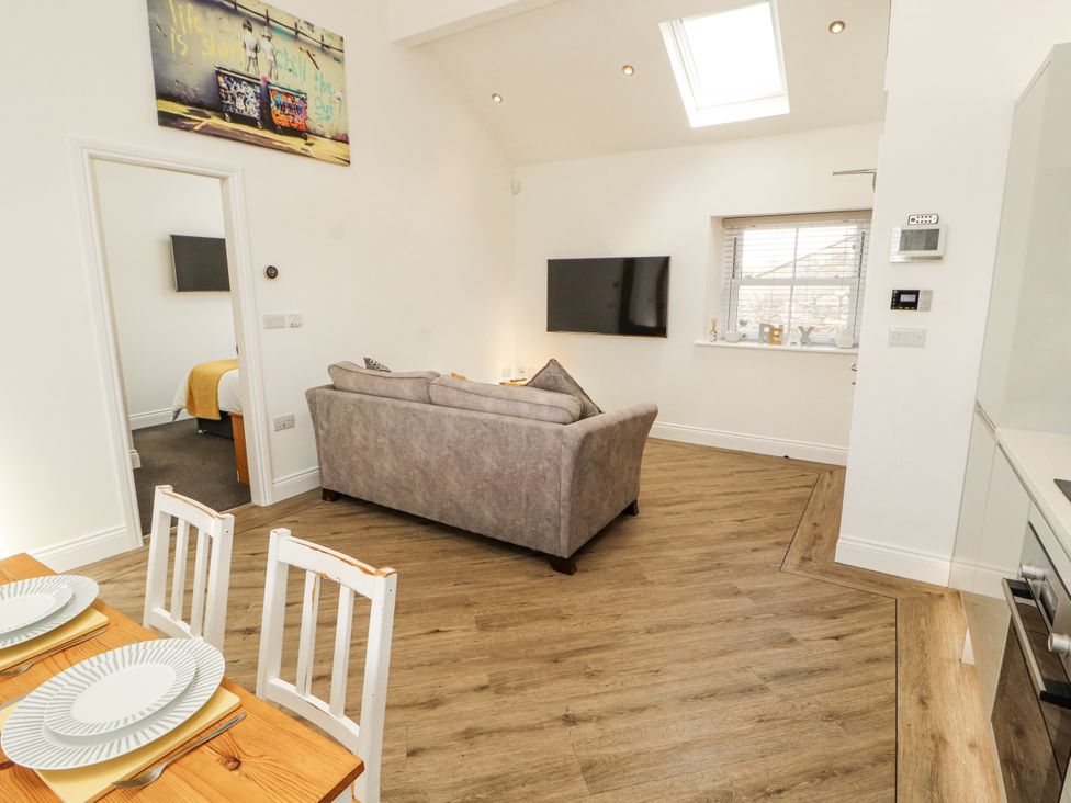 A living room with a sofa and dining table at Flat 2 in Carnforth