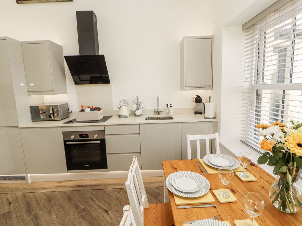 A kitchen with a dining table and appliances at Flat 2 in Carnforth