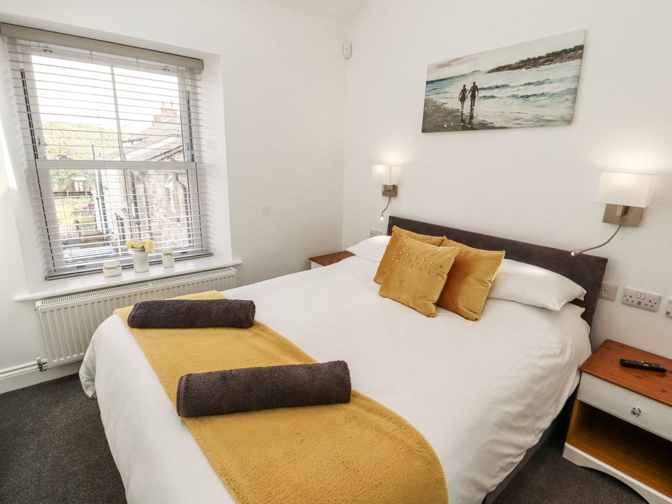 A bedroom with a bed and a window at Flat 2 in Carnforth