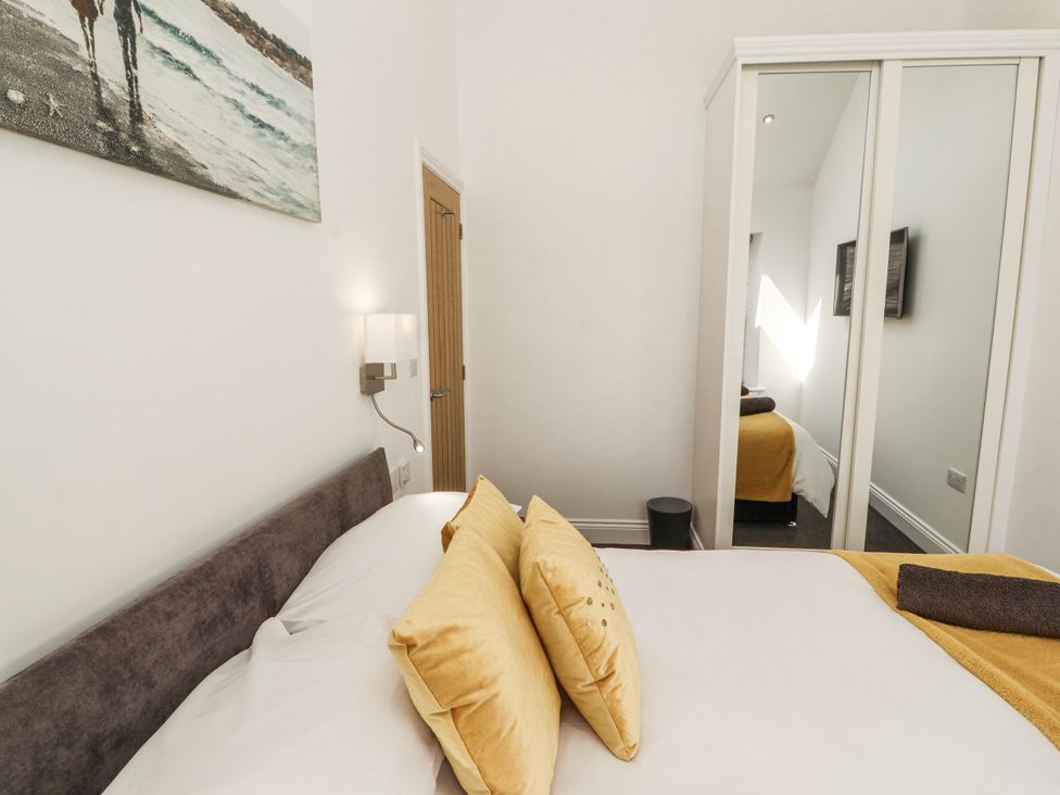 A bedroom with a bed and wardrobe at Flat 2 in Carnforth