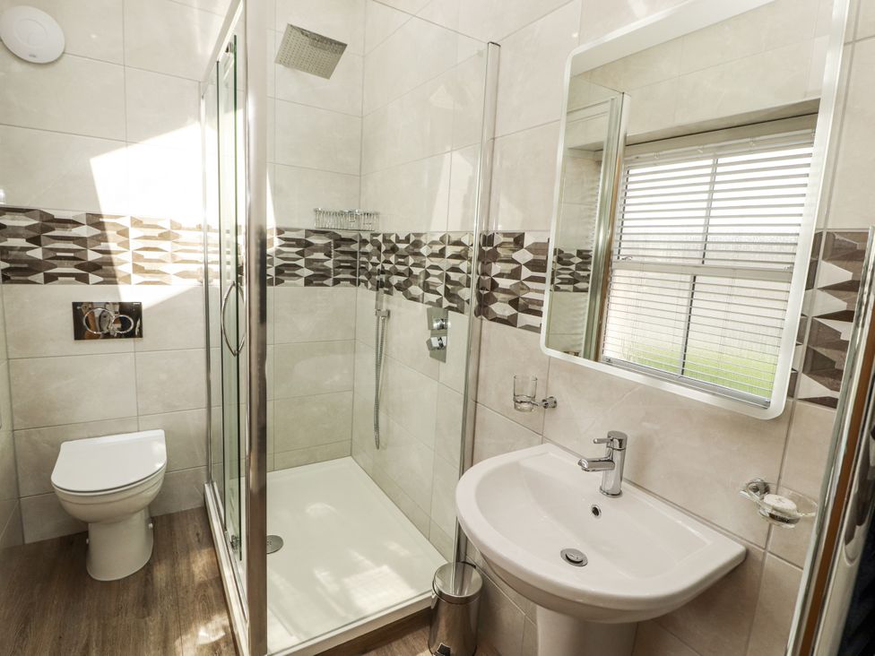 A bathroom with a shower, toilet, and sink at Flat 2 Carnforth