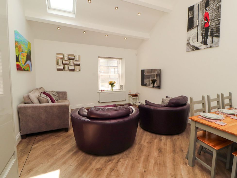 A living room with purple armchairs and a dining table at Flat 3 Carnforth