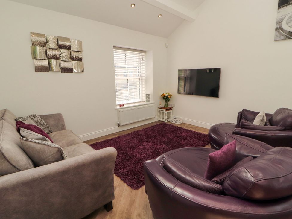 A living room with a sofa and armchairs at Flat 3 in Carnforth