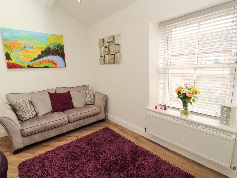 A living room with a couch and a window at Flat 3 in Carnforth
