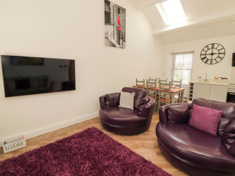 A living room with a television and sofa at Flat 3 in Carnforth