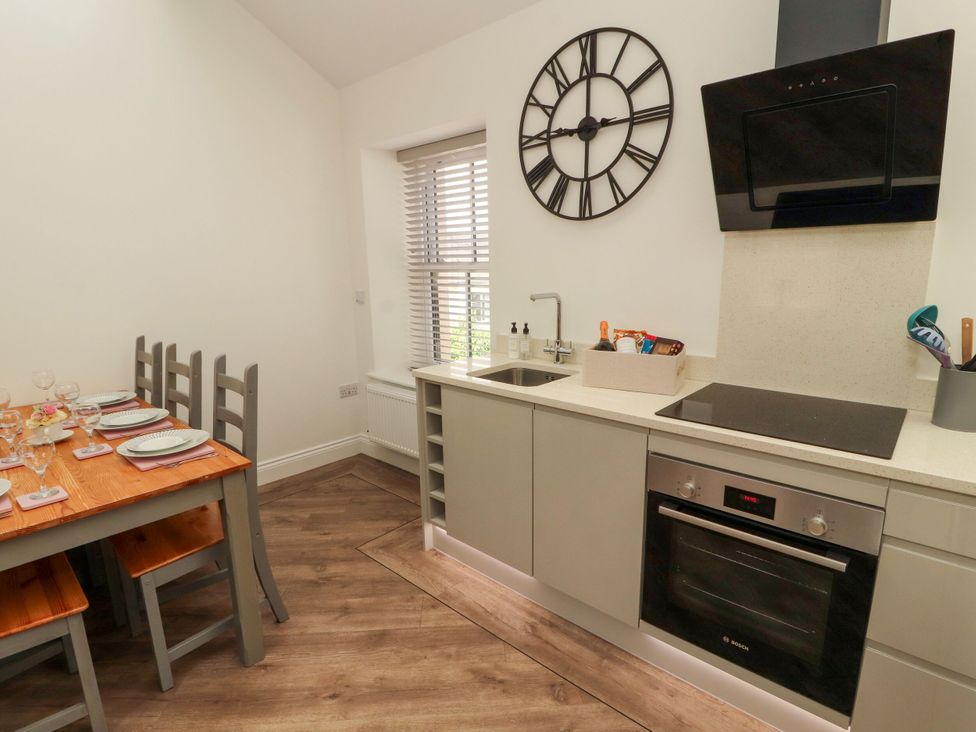 A kitchen with a dining table and chairs at Flat 3 Carnforth