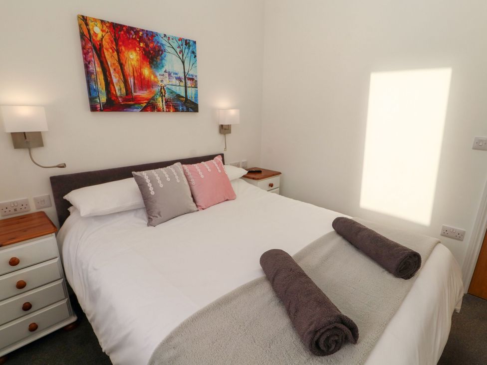 A bedroom with a bed and paintings at Flat 3 in Carnforth