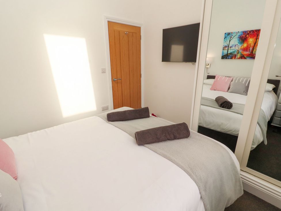 A bedroom with a bed and television at Flat 3 in Carnforth
