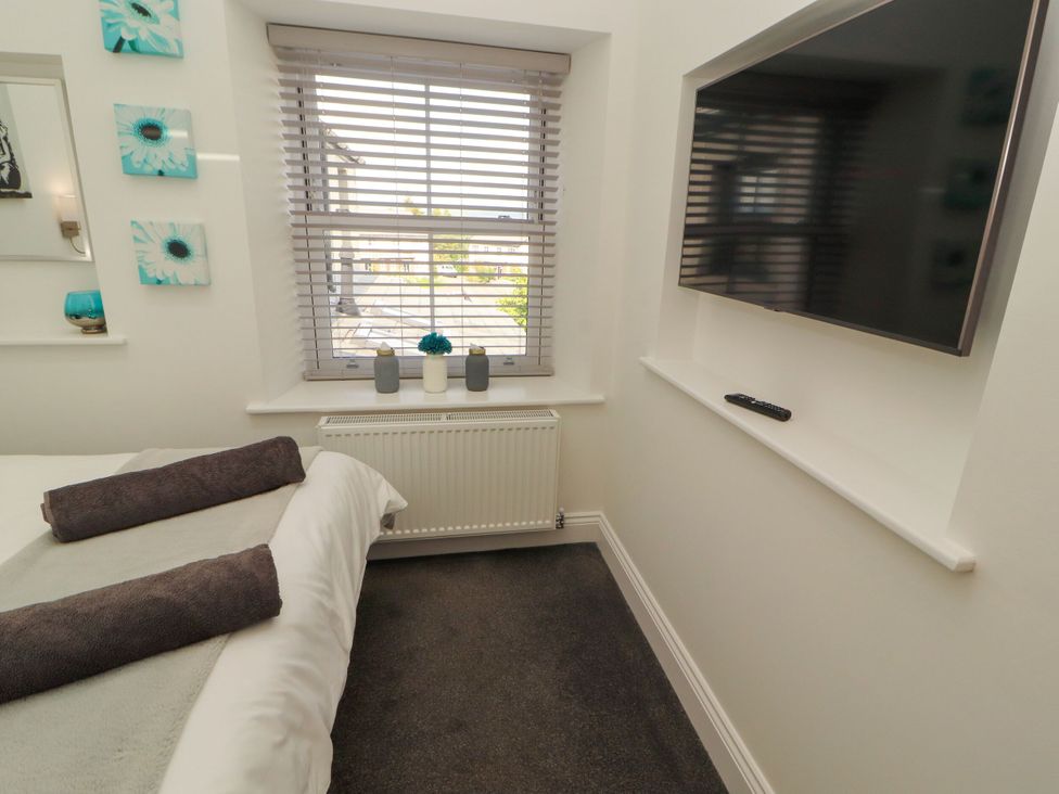 A bedroom with a bed and television at Flat 3 in Carnforth