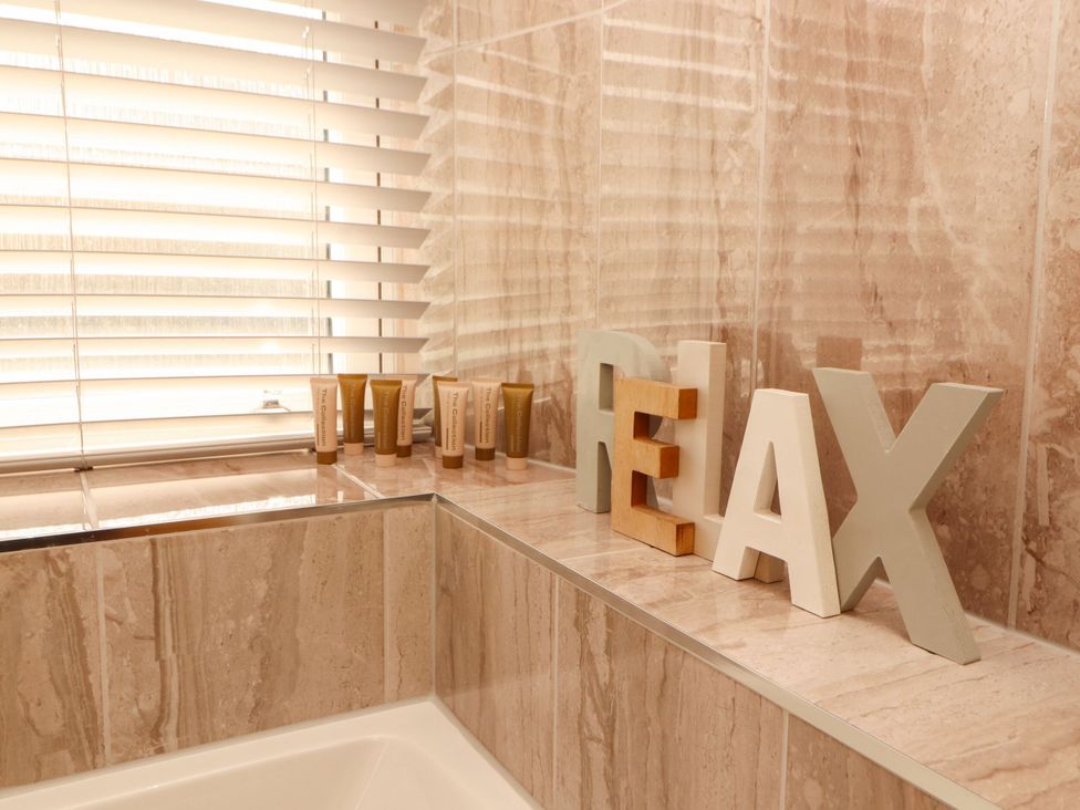 A bathroom with lotion tubes and relax letters at Flat 3 in Carnforth